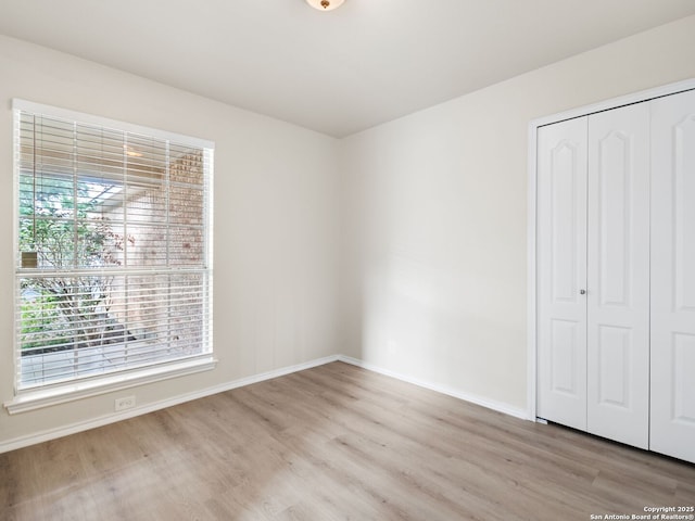 unfurnished bedroom featuring light hardwood / wood-style floors and a closet