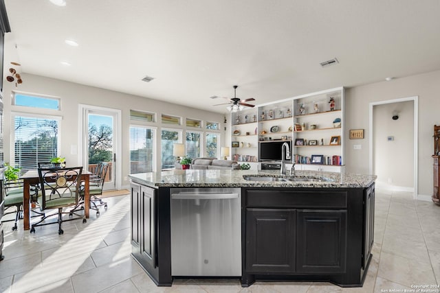 kitchen featuring light stone countertops, ceiling fan, sink, dishwasher, and an island with sink