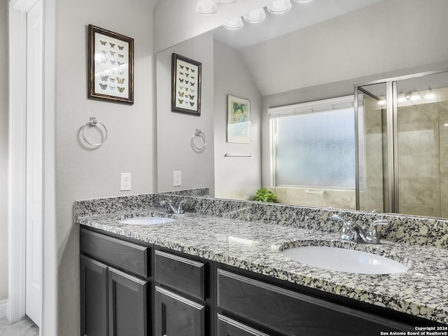 bathroom featuring vanity, a shower with shower door, and lofted ceiling