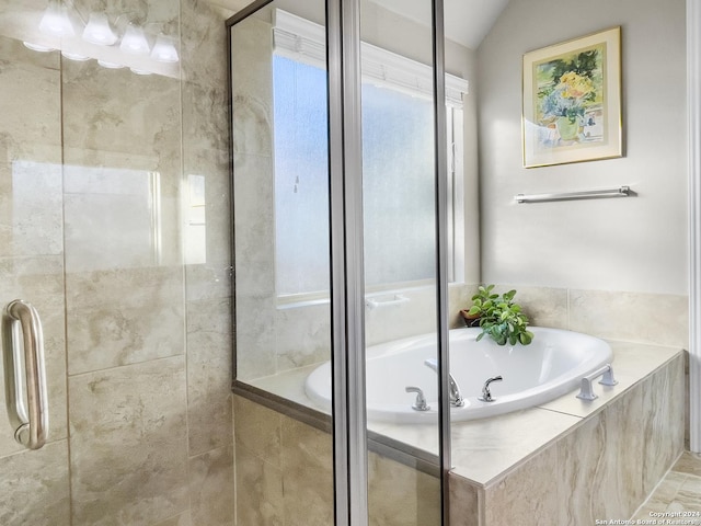 bathroom featuring shower with separate bathtub and vaulted ceiling