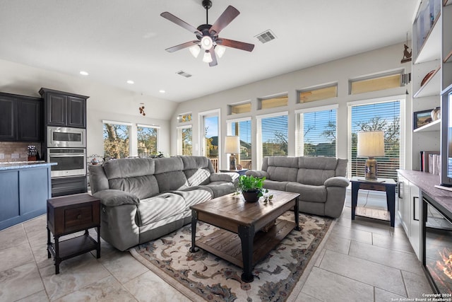 living room featuring lofted ceiling, ceiling fan, and a healthy amount of sunlight