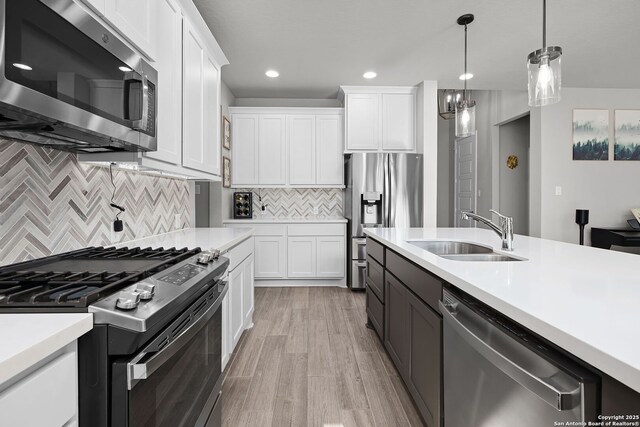 kitchen featuring appliances with stainless steel finishes, tasteful backsplash, white cabinetry, and sink