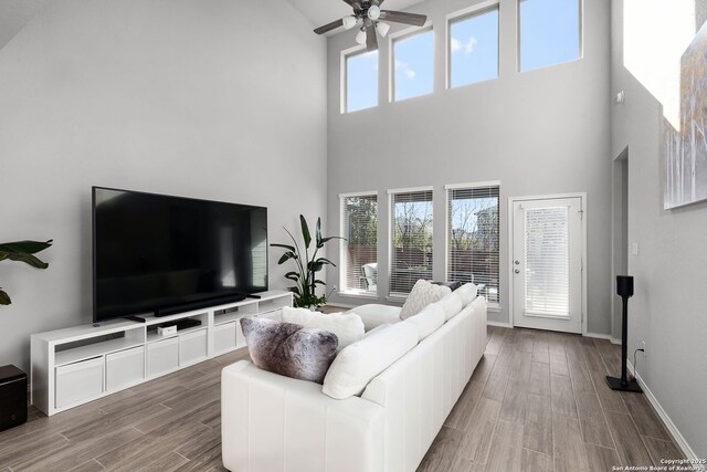 living room with a towering ceiling and ceiling fan