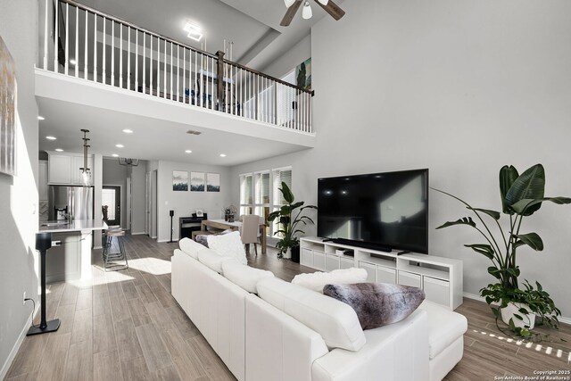 living room featuring a towering ceiling and ceiling fan