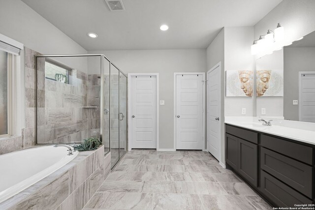 bathroom featuring vanity and independent shower and bath