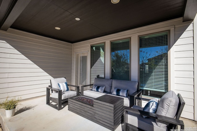 view of patio with an outdoor living space with a fire pit