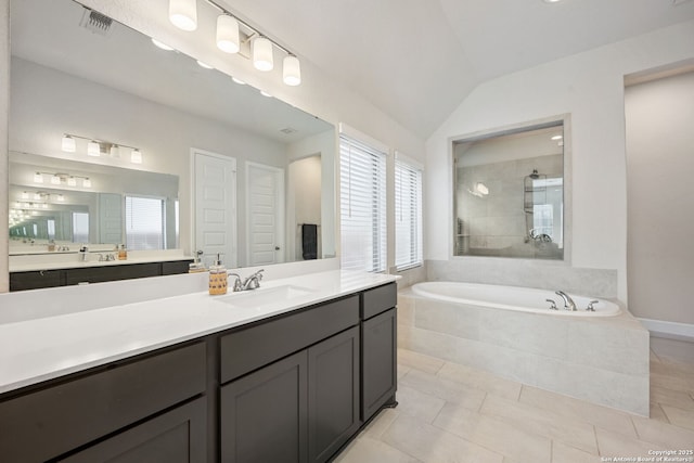 bathroom featuring tile patterned flooring, vanity, vaulted ceiling, and independent shower and bath