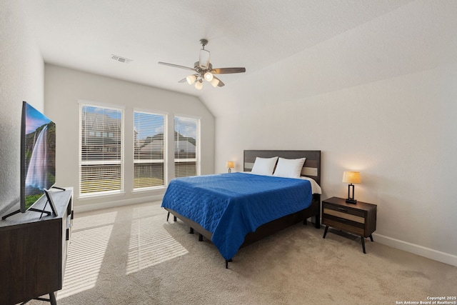 carpeted bedroom with ceiling fan and vaulted ceiling