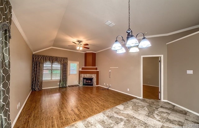 unfurnished living room featuring a tile fireplace, hardwood / wood-style floors, vaulted ceiling, ceiling fan with notable chandelier, and ornamental molding