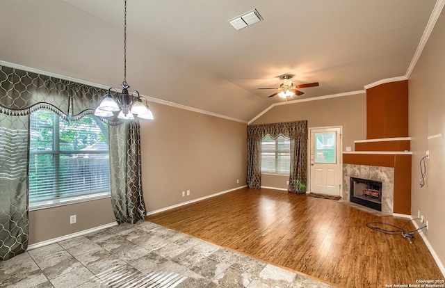 unfurnished living room featuring ornamental molding, ceiling fan with notable chandelier, vaulted ceiling, hardwood / wood-style floors, and a tiled fireplace