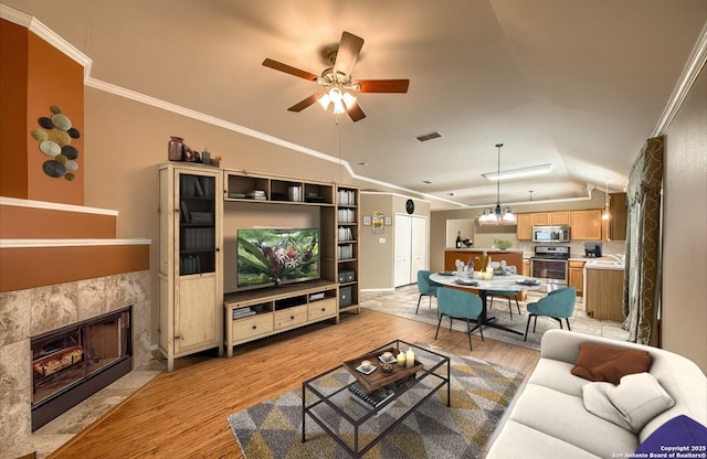 living room with lofted ceiling, light hardwood / wood-style flooring, ceiling fan, ornamental molding, and a fireplace