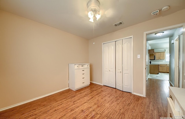 unfurnished bedroom with a closet and light hardwood / wood-style flooring