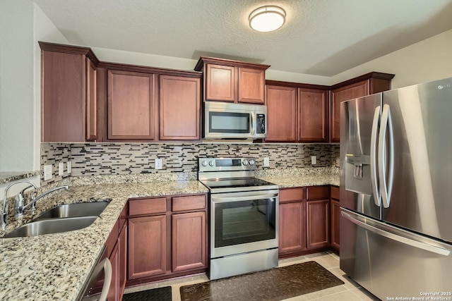 kitchen featuring tasteful backsplash, sink, light tile patterned flooring, and stainless steel appliances