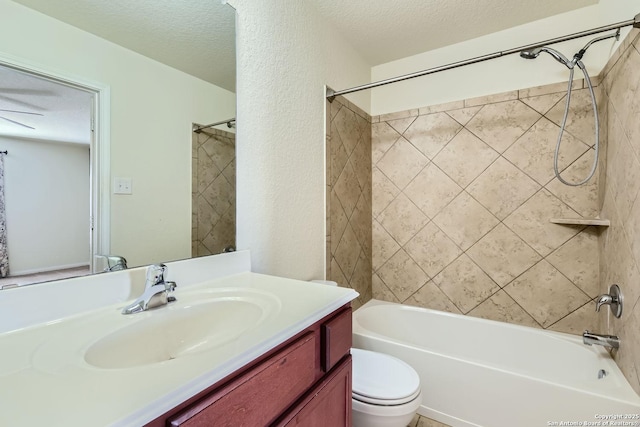 full bathroom featuring vanity, toilet, a textured ceiling, and tiled shower / bath