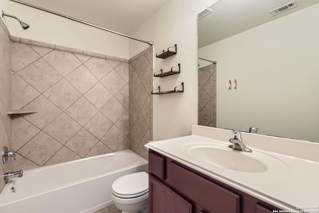 full bathroom featuring a textured ceiling, vanity, toilet, and tiled shower / bath