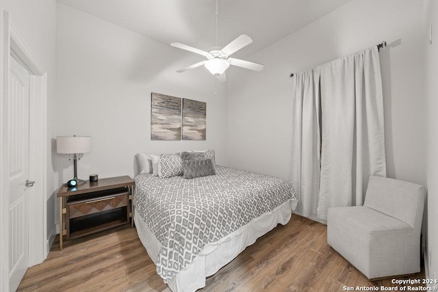 bedroom with hardwood / wood-style flooring, ceiling fan, and lofted ceiling