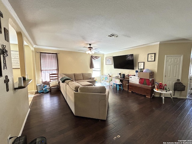 living room featuring a textured ceiling, dark hardwood / wood-style flooring, and ornamental molding