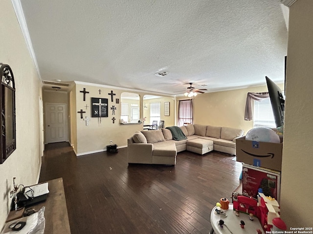 living room with crown molding, ceiling fan, dark hardwood / wood-style floors, and a textured ceiling