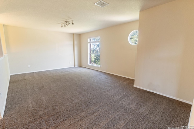 carpeted empty room with track lighting