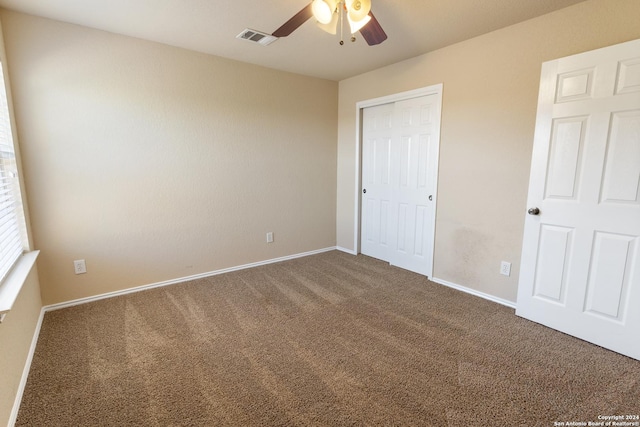 unfurnished bedroom with carpet, ceiling fan, and a closet