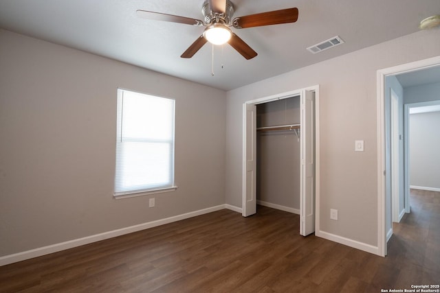 unfurnished bedroom with ceiling fan, dark wood-type flooring, and a closet