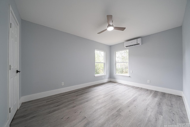 unfurnished room featuring hardwood / wood-style flooring, ceiling fan, and a wall unit AC