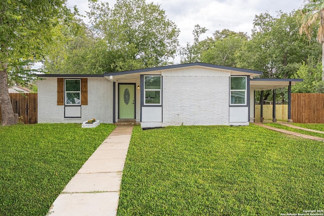 view of front of property featuring a front lawn and a carport