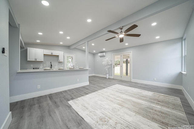 unfurnished living room featuring ceiling fan, lofted ceiling, and light hardwood / wood-style flooring