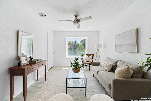 living room with light hardwood / wood-style flooring and ceiling fan