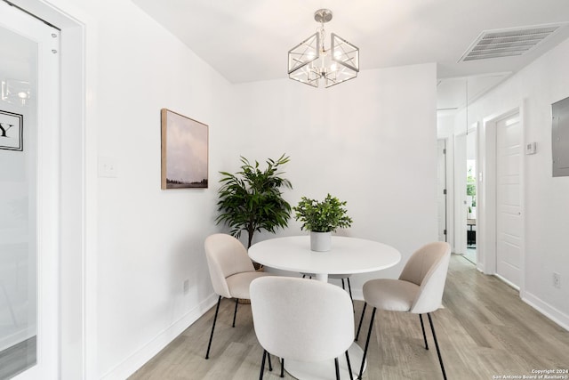 dining room with an inviting chandelier and light hardwood / wood-style flooring