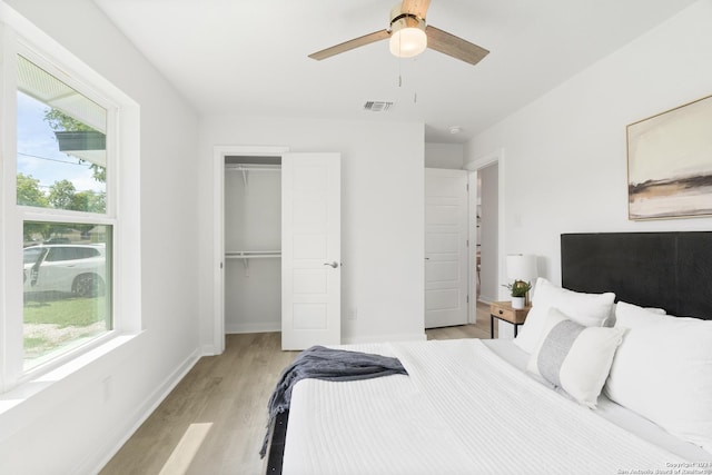 bedroom with multiple windows, ceiling fan, a closet, and light hardwood / wood-style floors