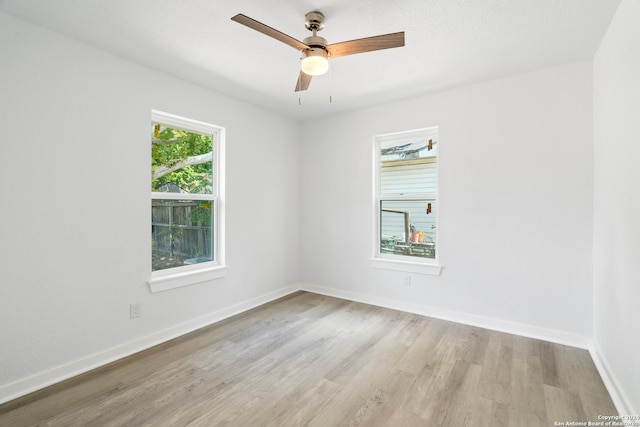 unfurnished room with plenty of natural light, ceiling fan, and light hardwood / wood-style flooring