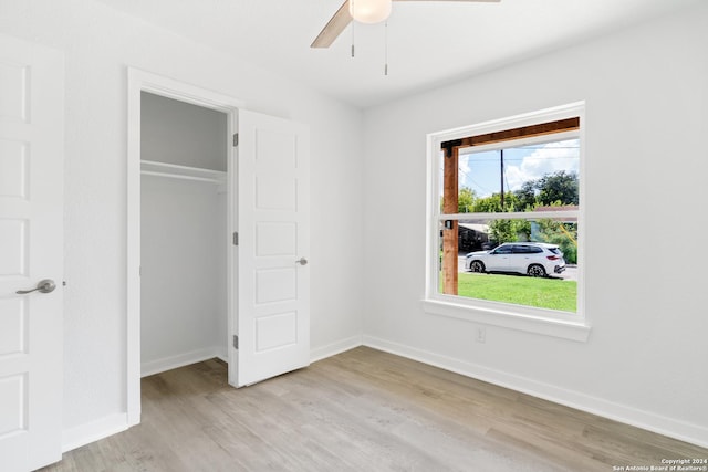 unfurnished bedroom featuring ceiling fan, light wood-type flooring, and a closet