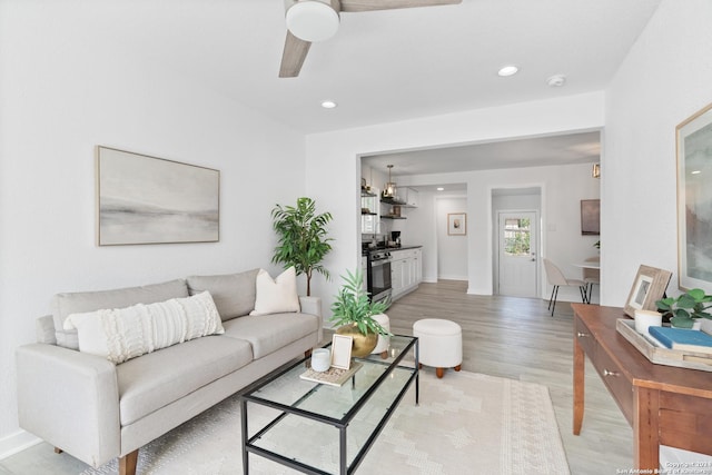 living room featuring ceiling fan and light hardwood / wood-style flooring