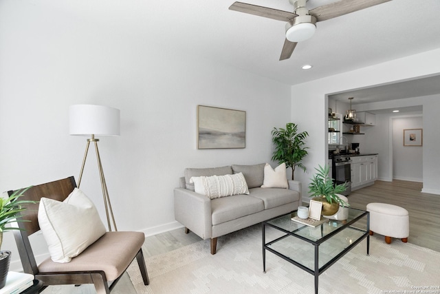 living room featuring light hardwood / wood-style floors and ceiling fan