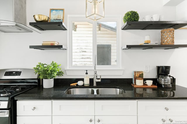 kitchen featuring white cabinets, gas stove, and extractor fan