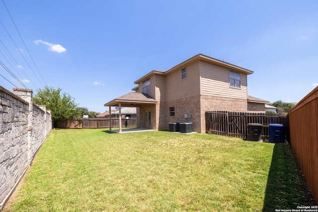 rear view of property featuring a yard, cooling unit, and a patio area