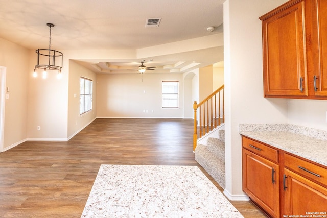 interior space with hardwood / wood-style floors, ceiling fan, and a tray ceiling