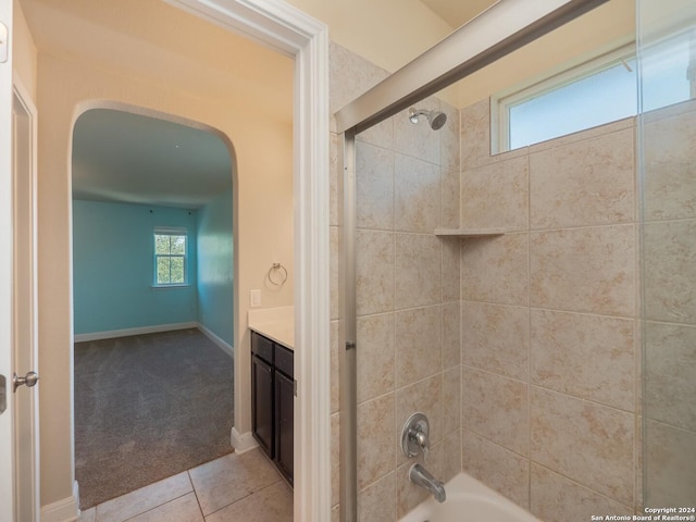 bathroom featuring tile patterned flooring, tiled shower / bath combo, and vanity