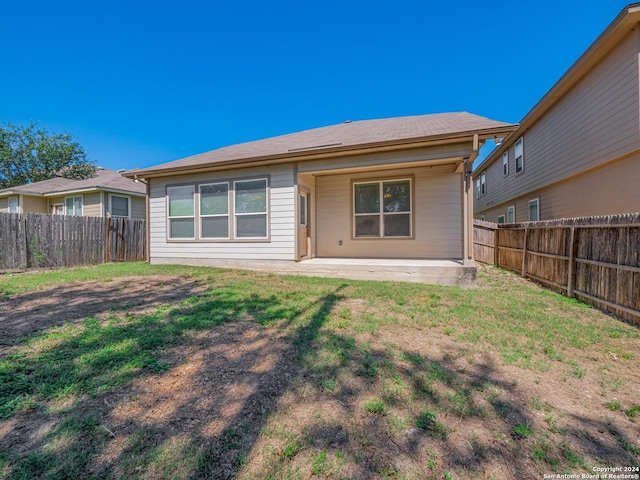 rear view of house featuring a patio area and a lawn