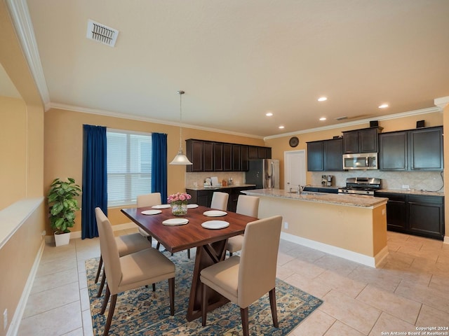 tiled dining space featuring sink and crown molding