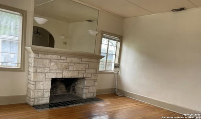 room details featuring hardwood / wood-style floors and a stone fireplace