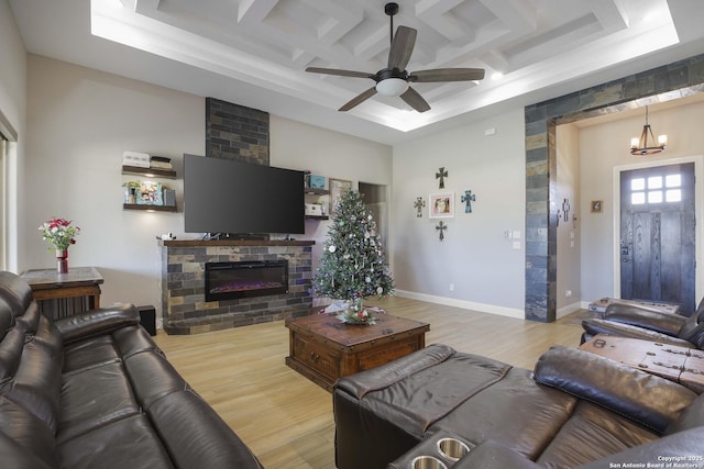 living room with ceiling fan with notable chandelier, light hardwood / wood-style floors, beam ceiling, and coffered ceiling