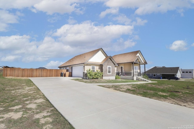 view of front of house featuring covered porch, a garage, and a front lawn