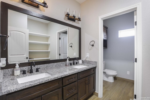 bathroom featuring toilet, vanity, and hardwood / wood-style flooring