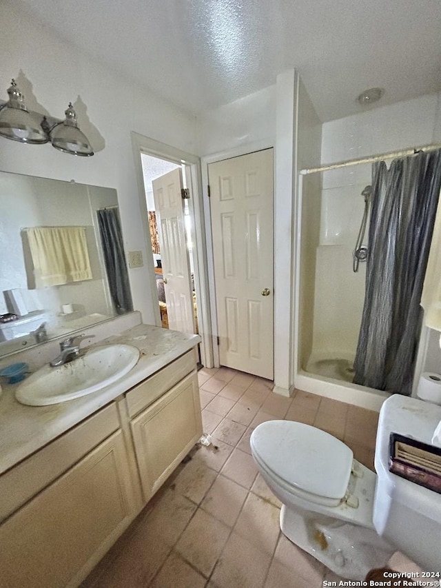 bathroom with a shower with shower curtain, vanity, a textured ceiling, tile patterned flooring, and toilet