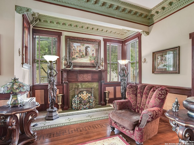 sitting room with a fireplace, hardwood / wood-style floors, and crown molding