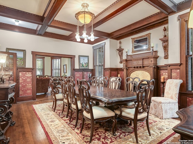 dining area featuring beam ceiling, a chandelier, coffered ceiling, and hardwood / wood-style flooring