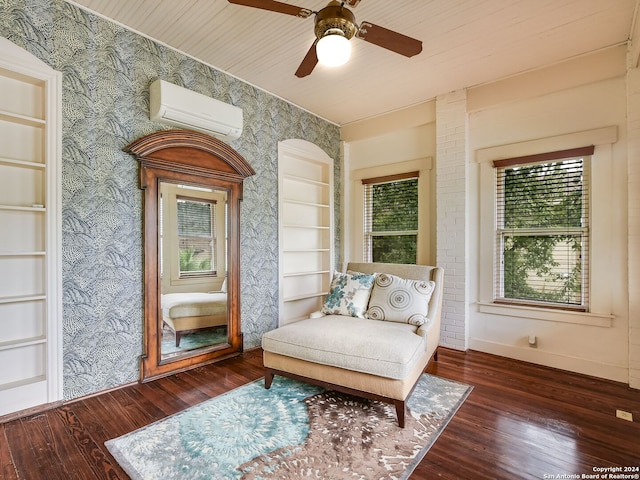 living area featuring built in features, dark hardwood / wood-style flooring, an AC wall unit, and ceiling fan