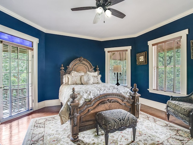 bedroom with ceiling fan, ornamental molding, and multiple windows